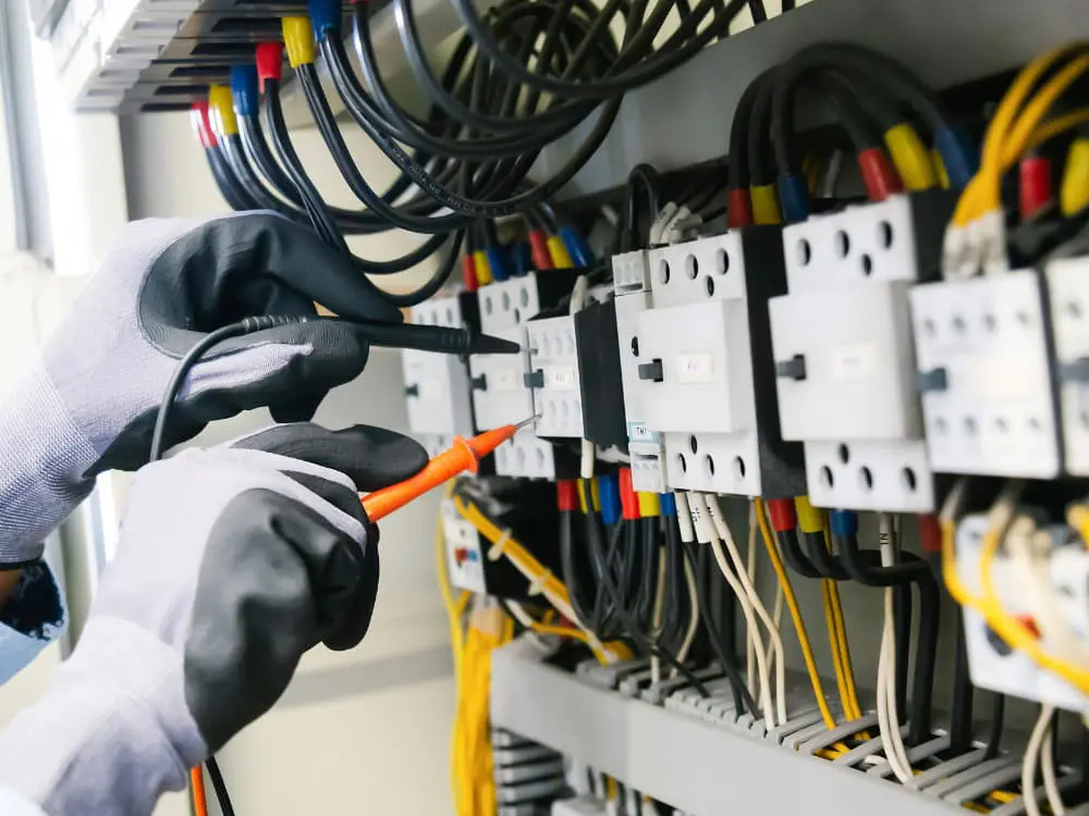 Técnico a testar um quadro eléctrico com multímetro durante a instalação eléctrica de uma casa